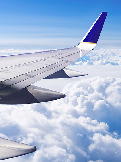Blick aus Flugzeug über den Wolken auf den Flugzeugflügel