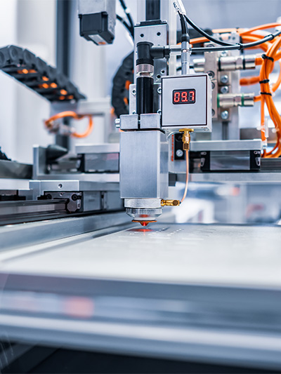 Eine silberne Maschine mit orangenen Kabeln und Laser