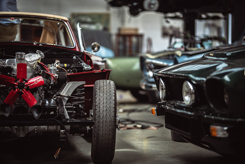 belis-oberflaechentechnik-branchen-restaurierung Verschiedene Oldtimer Automobile in Werkstatt