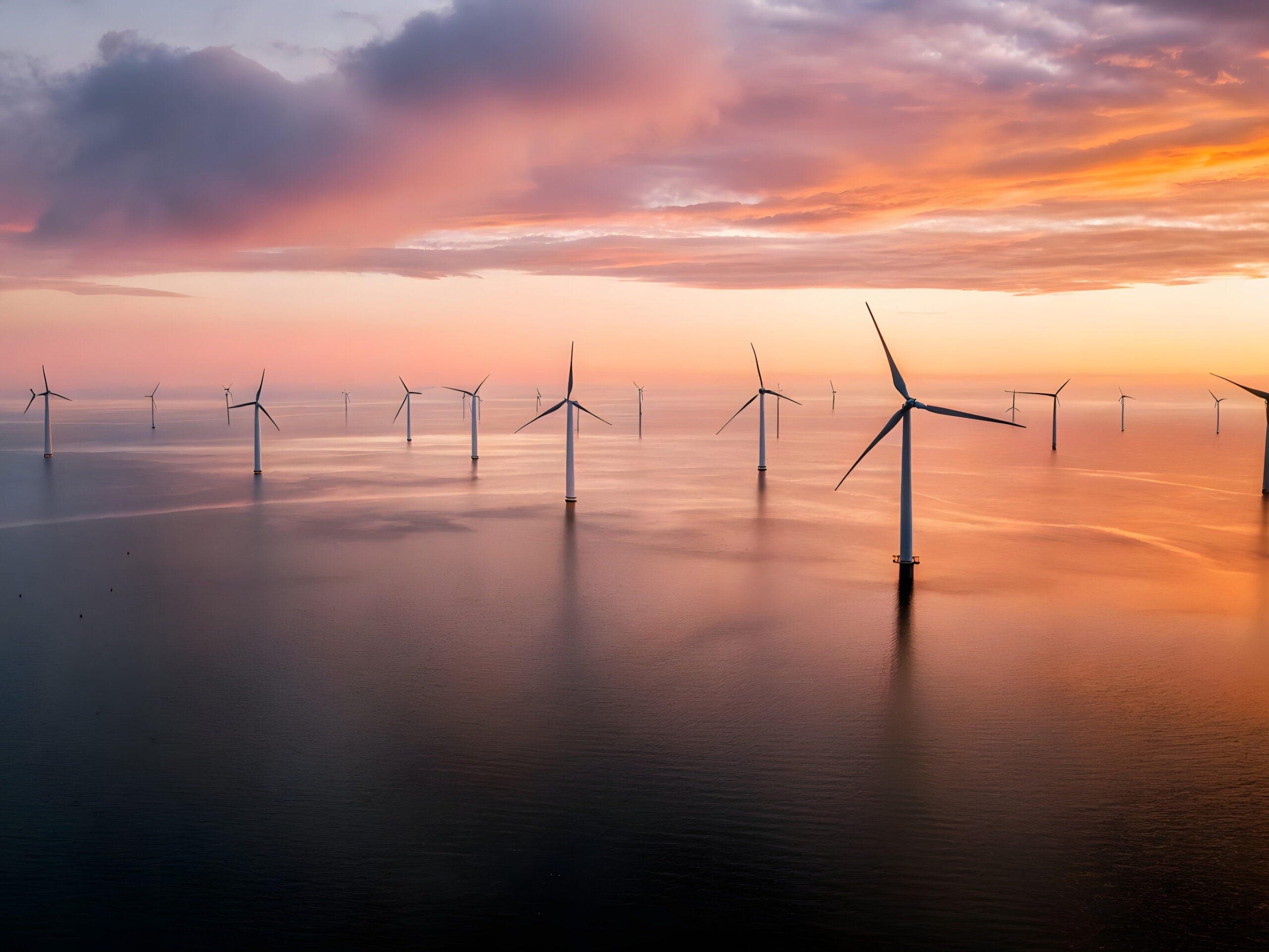 belis-oberflaechentechnik-branchen-windkraftundoffshoreanlagen Offshore-Windkrafträder auf dem offenen Meer bei Sonnenuntergang